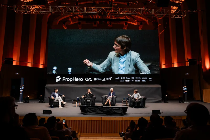 Panel sobre el escenario con un ponente en la pantalla gigante